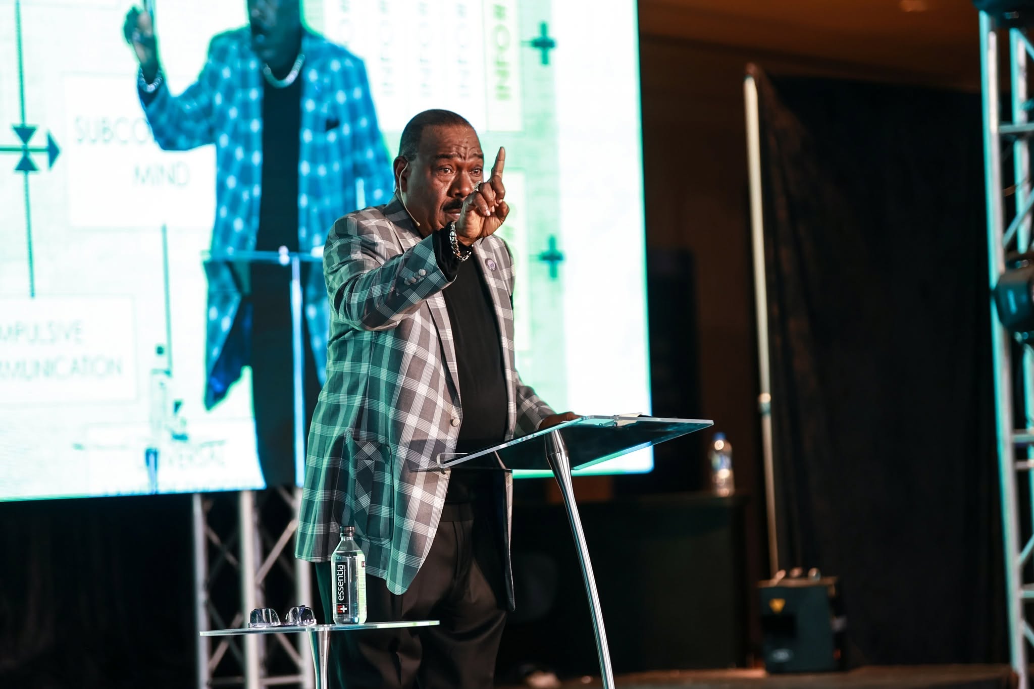 A speaker addresses a gathering from the stage